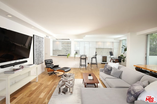 living room featuring wine cooler and light hardwood / wood-style floors