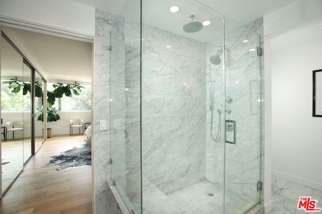 bathroom with an enclosed shower and wood-type flooring