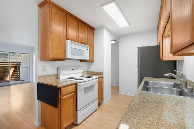 kitchen featuring white appliances, light wood-type flooring, and sink