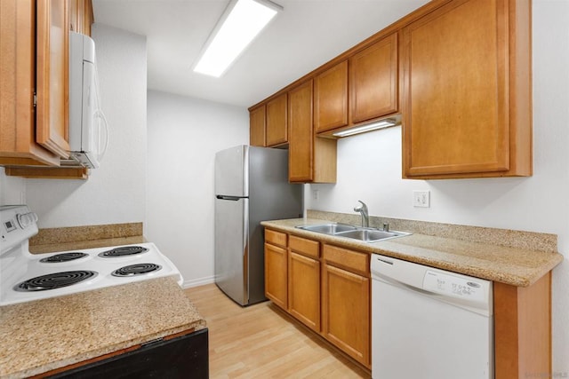 kitchen featuring sink, white appliances, and light hardwood / wood-style flooring