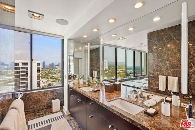 bathroom with vanity, a wealth of natural light, and expansive windows