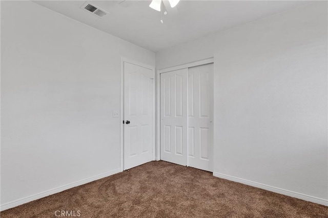 unfurnished bedroom featuring ceiling fan and dark colored carpet