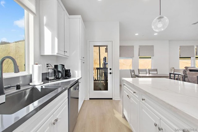 kitchen featuring sink, white cabinetry, dishwasher, light stone countertops, and pendant lighting