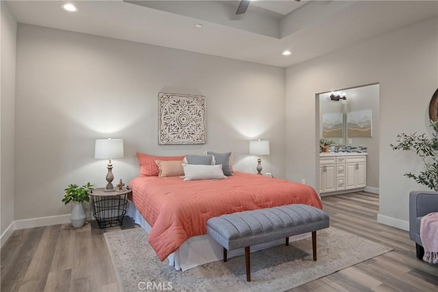 bedroom featuring ceiling fan, light hardwood / wood-style flooring, and ensuite bathroom