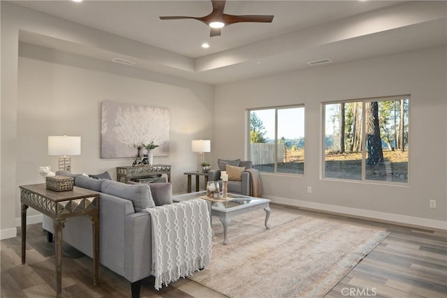 living room featuring ceiling fan, hardwood / wood-style floors, and a fireplace