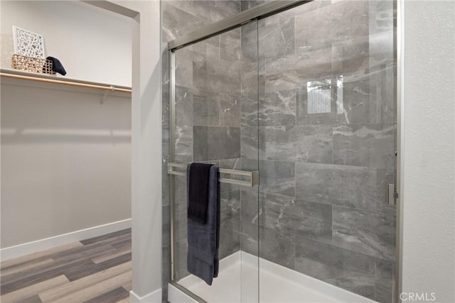 bathroom featuring a shower with shower door and hardwood / wood-style flooring