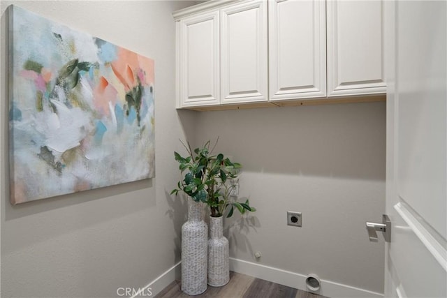 laundry room with cabinets, hardwood / wood-style floors, hookup for a gas dryer, and electric dryer hookup