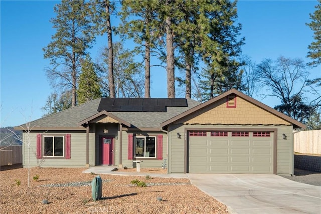 ranch-style home featuring a garage and solar panels