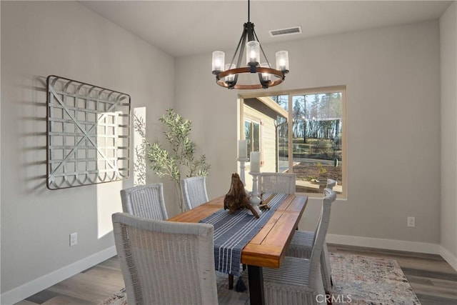 dining room with hardwood / wood-style floors and a notable chandelier