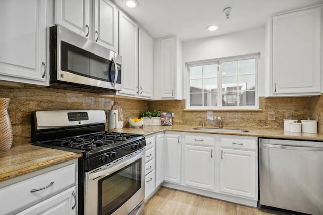 kitchen with white cabinets and appliances with stainless steel finishes