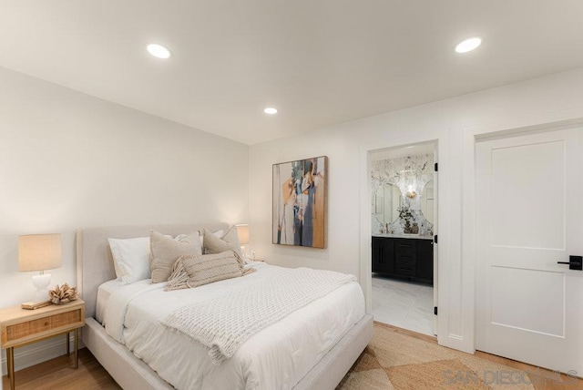 bedroom featuring ensuite bathroom and hardwood / wood-style flooring