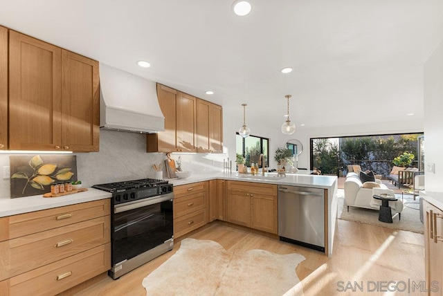 kitchen with range with gas cooktop, dishwasher, decorative light fixtures, premium range hood, and sink