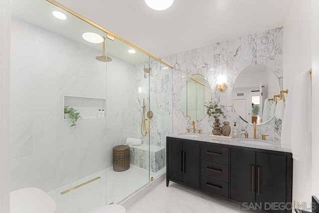 bathroom with toilet, tile walls, a shower with shower door, and vanity