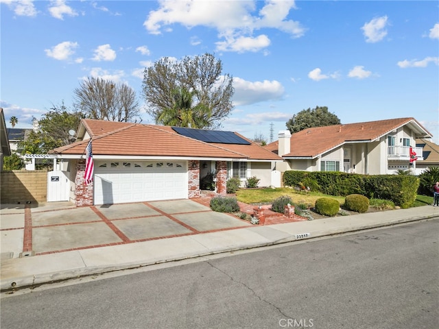 ranch-style house featuring solar panels and a garage