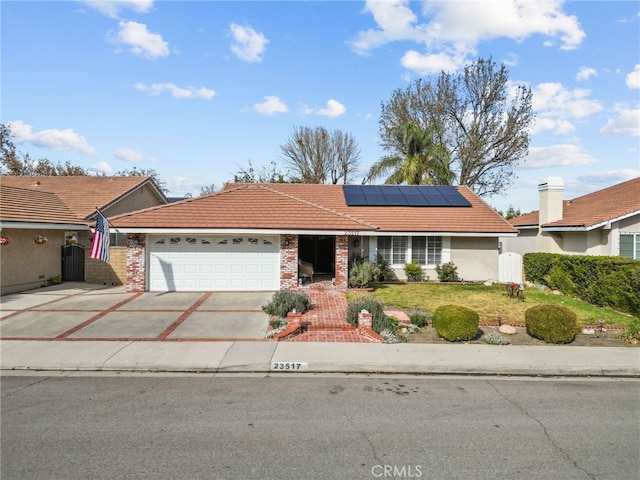 ranch-style house featuring solar panels, a front lawn, and a garage