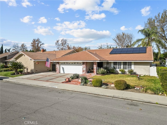 single story home featuring a garage, a front lawn, and solar panels