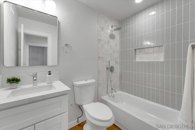 full bathroom featuring toilet, vanity, and tiled shower / bath combo