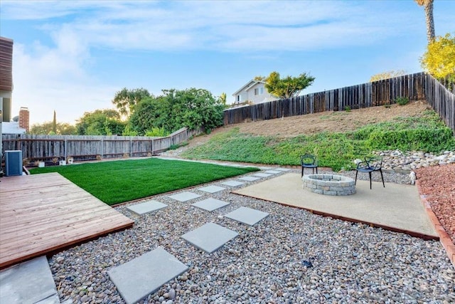 view of yard featuring a wooden deck, an outdoor fire pit, and a patio area