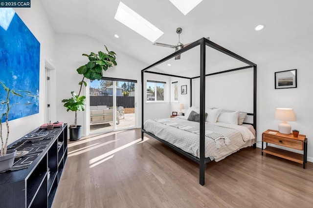 bedroom featuring lofted ceiling with skylight, access to outside, and wood-type flooring