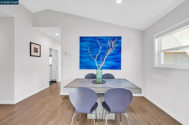 dining space with wood-type flooring and lofted ceiling