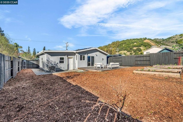 rear view of property featuring a patio area and an outdoor living space