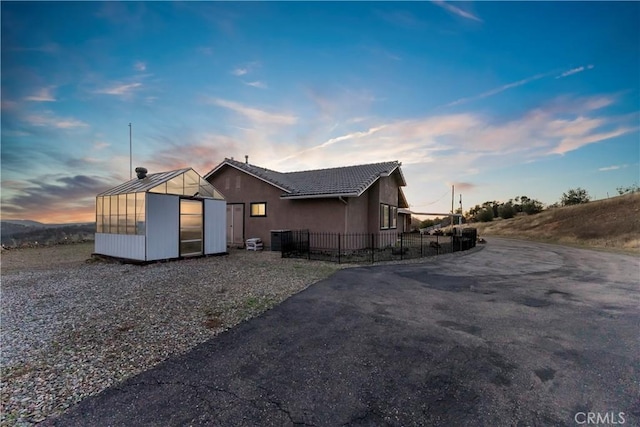 property exterior at dusk with an outbuilding