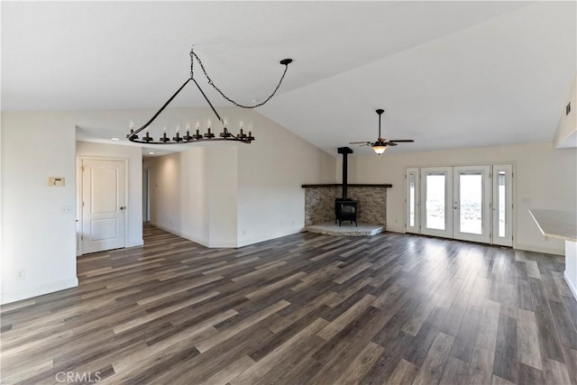 unfurnished living room with ceiling fan, a wood stove, dark hardwood / wood-style floors, french doors, and vaulted ceiling