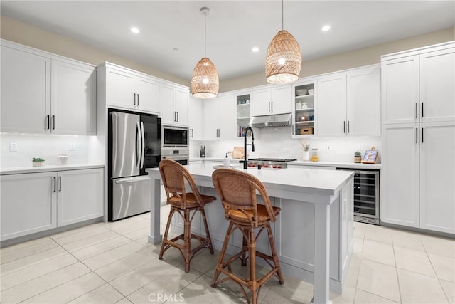 kitchen featuring light tile patterned floors, wine cooler, appliances with stainless steel finishes, light countertops, and under cabinet range hood