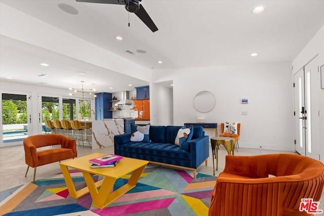 living room featuring ceiling fan with notable chandelier