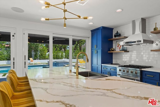 kitchen featuring light stone countertops, extractor fan, high end range, backsplash, and blue cabinets