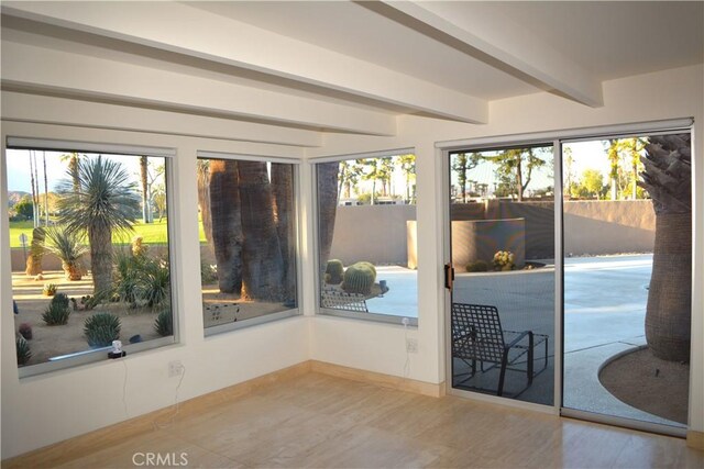 doorway to outside with beam ceiling