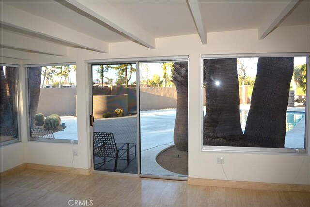 doorway to outside with hardwood / wood-style flooring and beamed ceiling