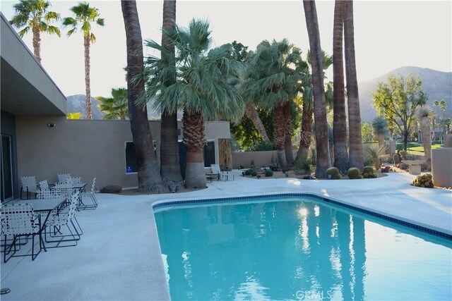 view of swimming pool with a patio and a mountain view