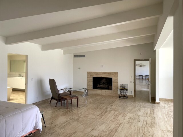 bedroom featuring a fireplace and beamed ceiling