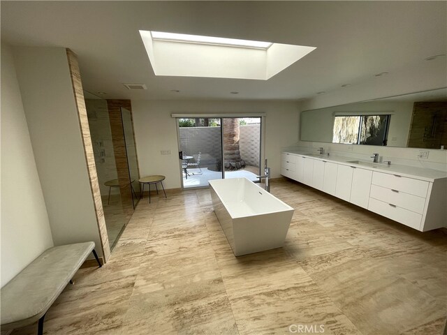 bathroom featuring vanity, a skylight, and separate shower and tub