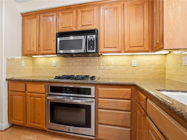 kitchen with stainless steel appliances, light wood-type flooring, stone countertops, and decorative backsplash