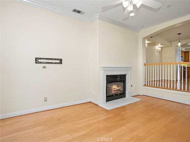 unfurnished living room featuring light wood-type flooring, ceiling fan, and crown molding