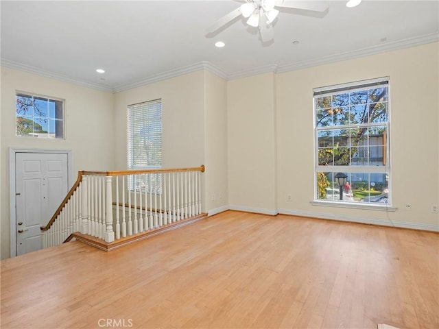 empty room featuring ceiling fan, light wood-type flooring, and crown molding