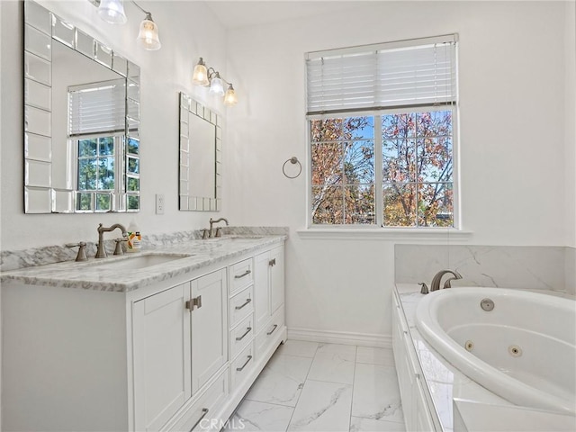 bathroom featuring tiled bath, vanity, and plenty of natural light