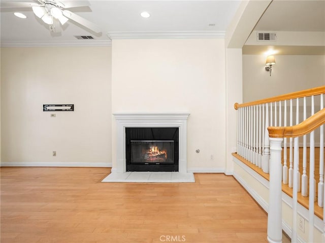 unfurnished living room with ceiling fan, crown molding, and light hardwood / wood-style flooring