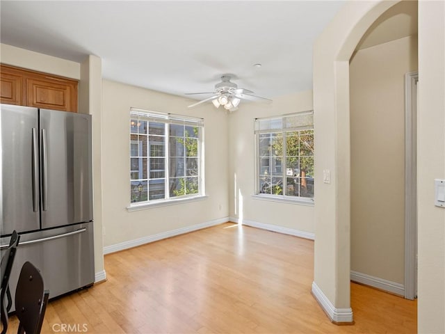 kitchen featuring ceiling fan, stainless steel fridge, and light wood-type flooring