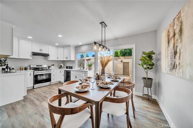 dining room with light hardwood / wood-style floors and sink