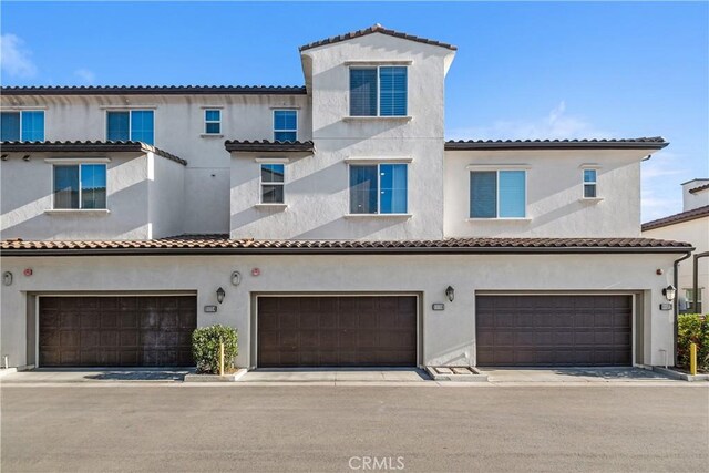 mediterranean / spanish home featuring a garage