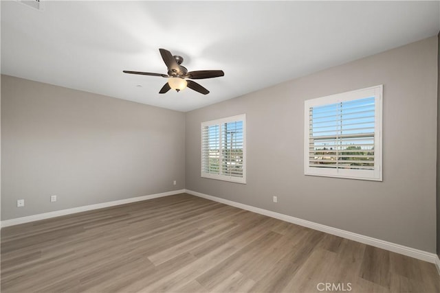 spare room with hardwood / wood-style flooring and ceiling fan