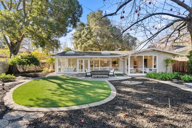 back of house featuring a sunroom, a patio, and french doors