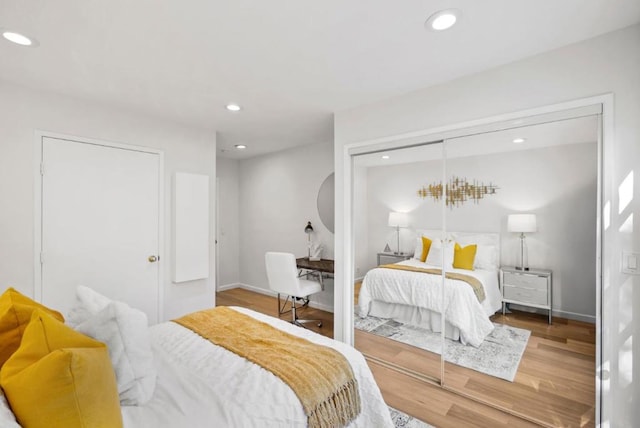 bedroom featuring a closet, hardwood / wood-style flooring, and a chandelier