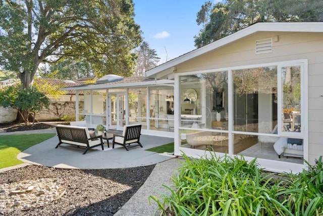 view of patio featuring outdoor lounge area, a sunroom, and french doors