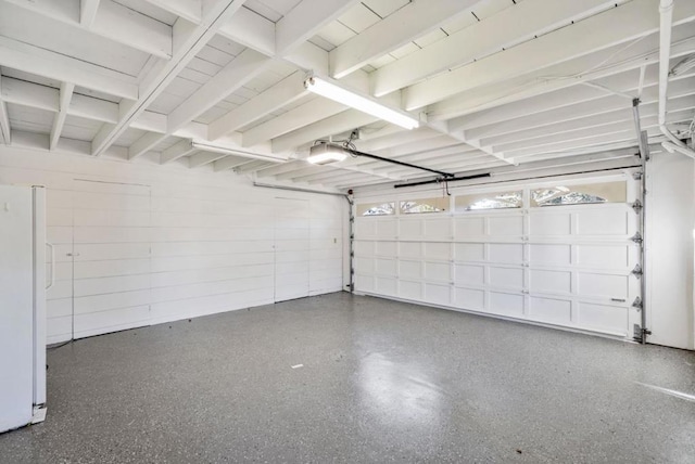 garage featuring white refrigerator and a garage door opener