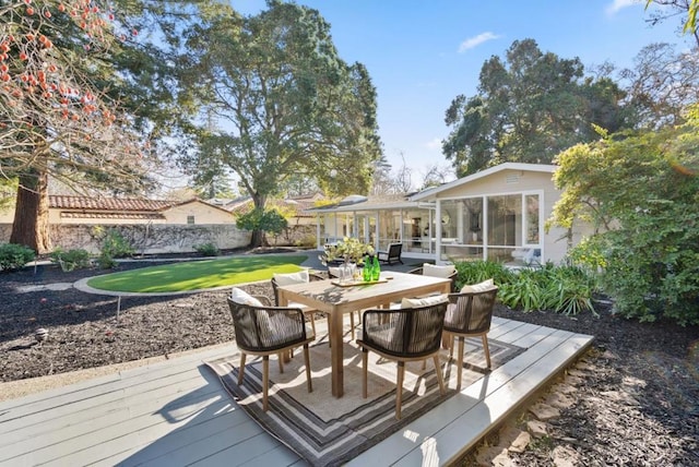 deck with a yard and a sunroom