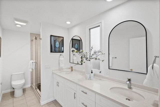 bathroom featuring vanity, toilet, tile patterned floors, and a shower with door